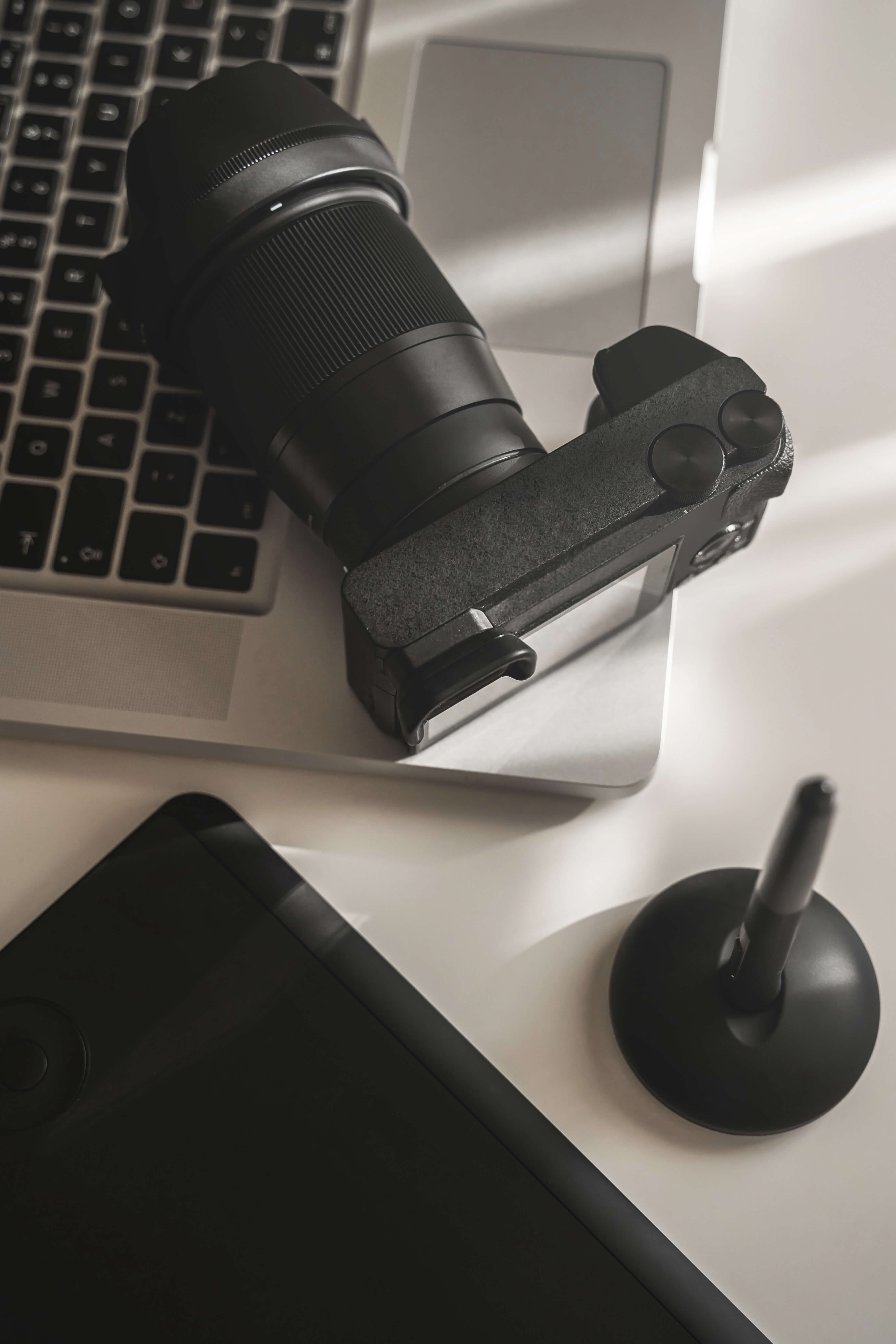 Photographer's workplace with a modern equipment. Mirrorless camera, laptop and graphics tablet.