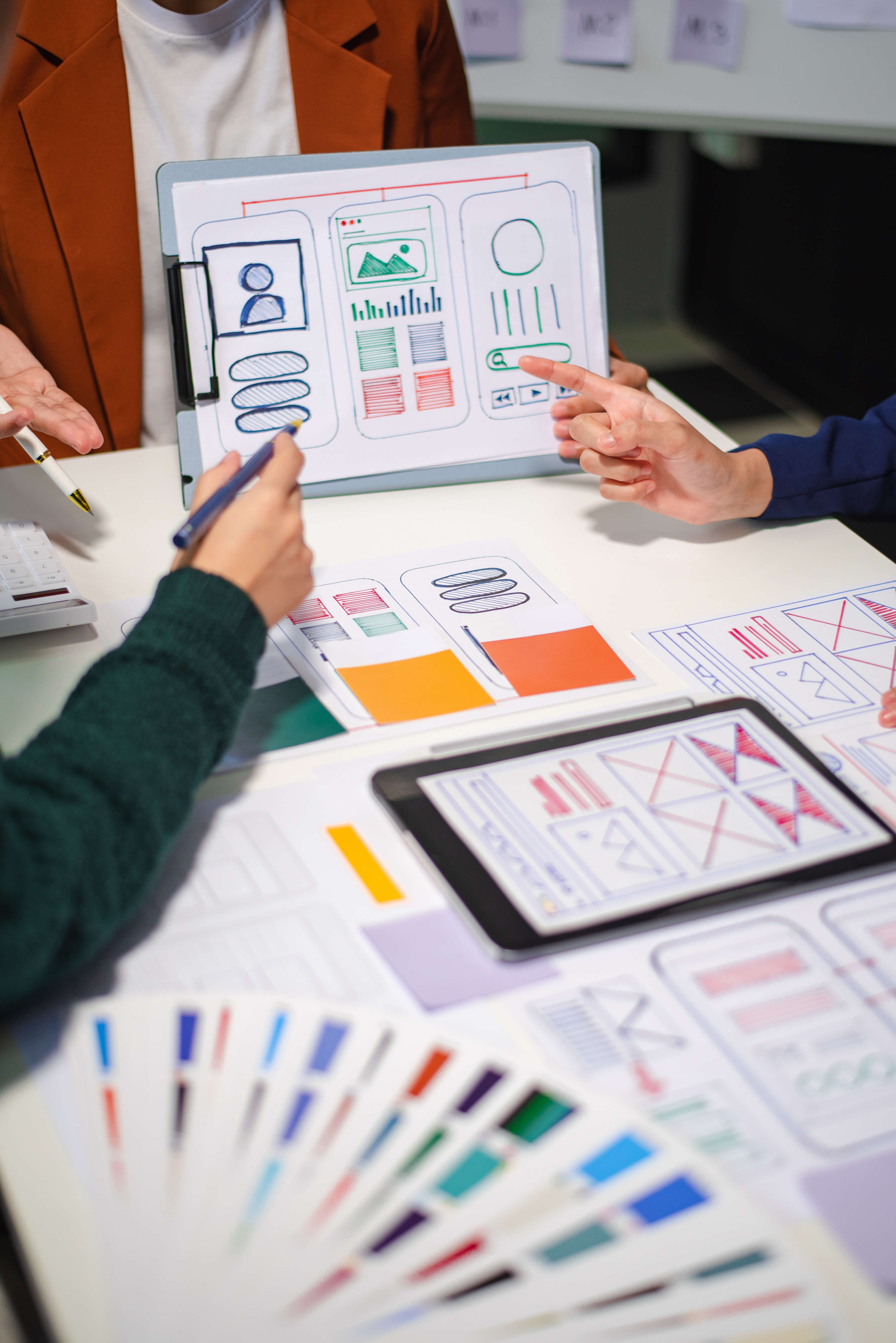 Close up view of UI developer team brainstorming on their project with laptop, smartphone and digital tablet. Creative digital development agency.