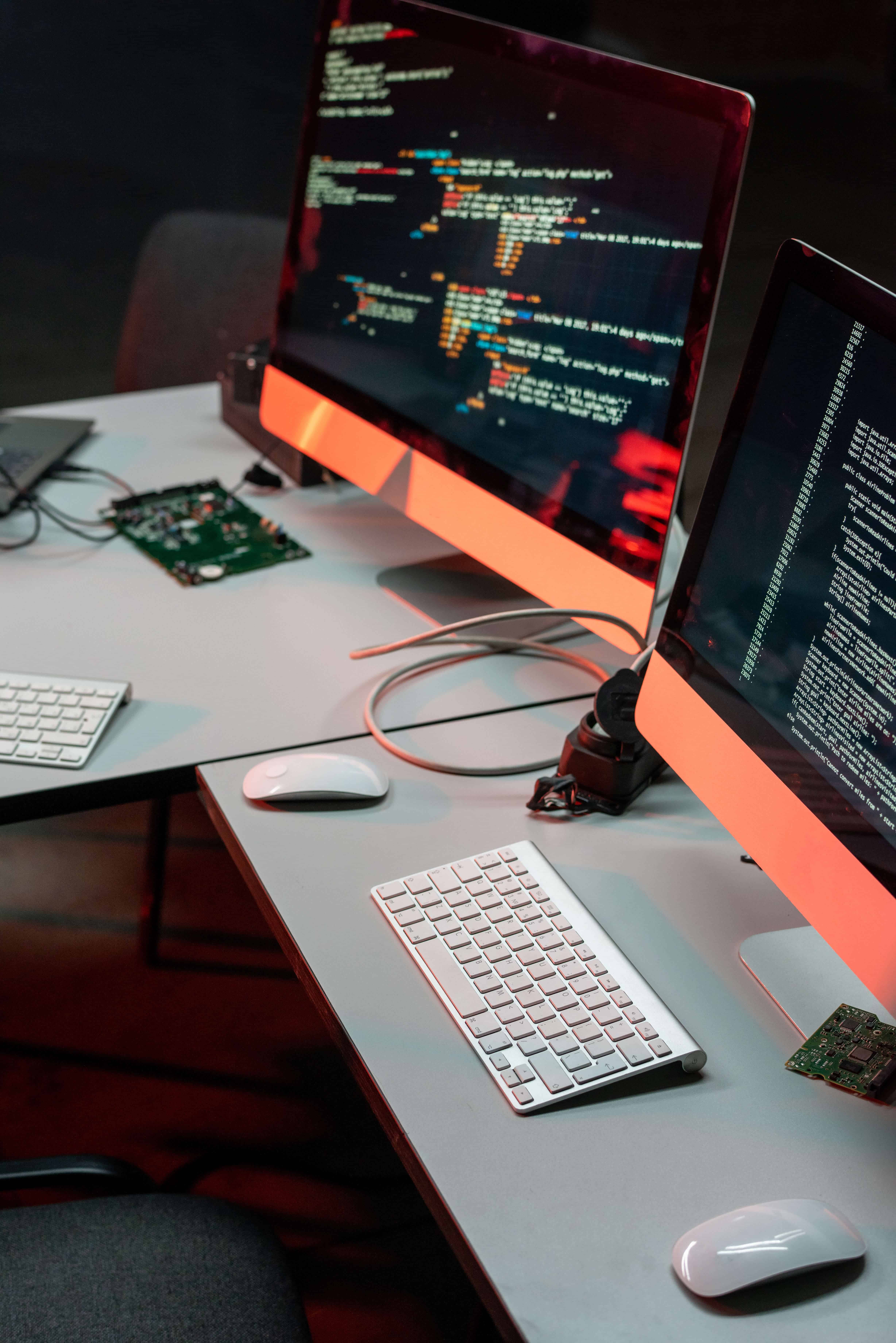 Two computer monitors with coded data on screens